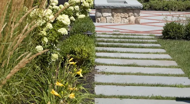 Linear stepping stone path through green lawn
