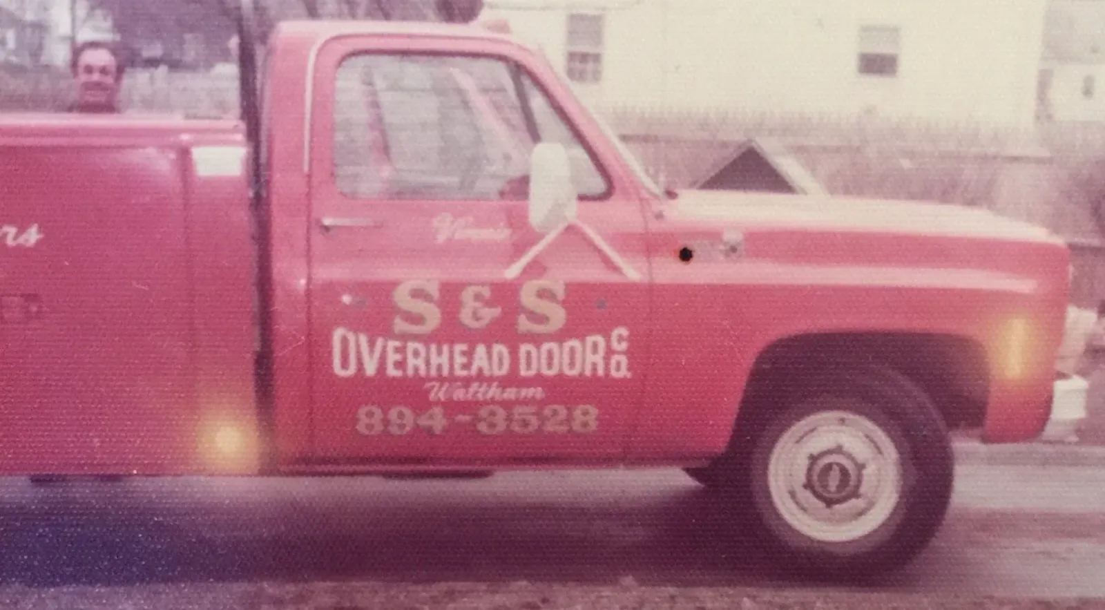 Gary Scalese of S&S Overhead Door Waltham, MA posing in front of his red vintage company truck.