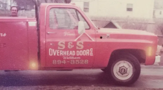 Gary Scalese of S&S Overhead Door Waltham, MA posing in front of his red vintage company truck.