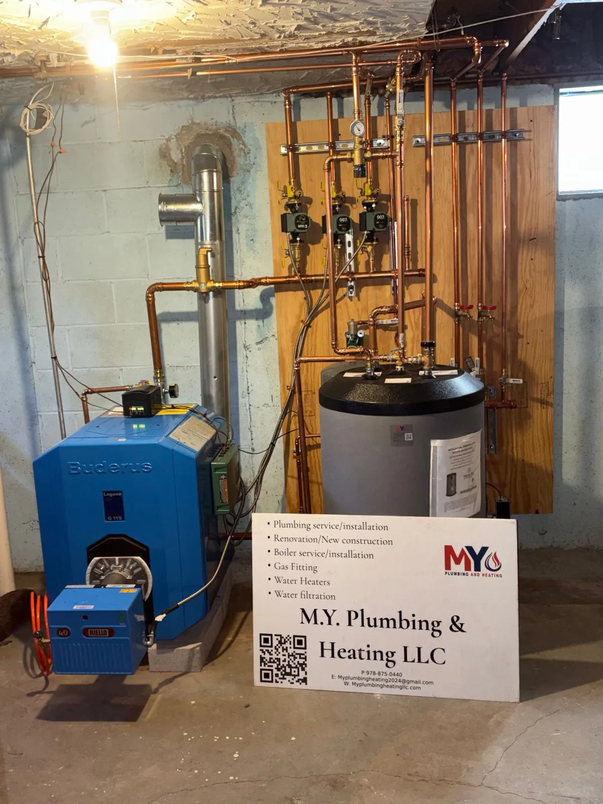 Blue furnace and water heater with copper pipes in a basement.