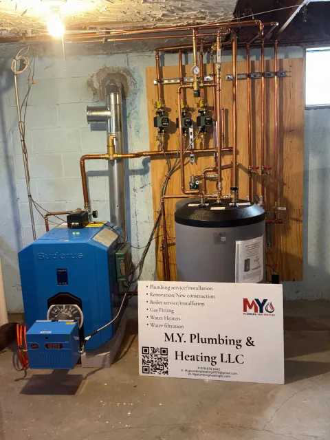 Blue furnace and water heater with copper pipes in a basement.