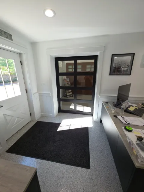 Interior showroom with various garage door styles on display.