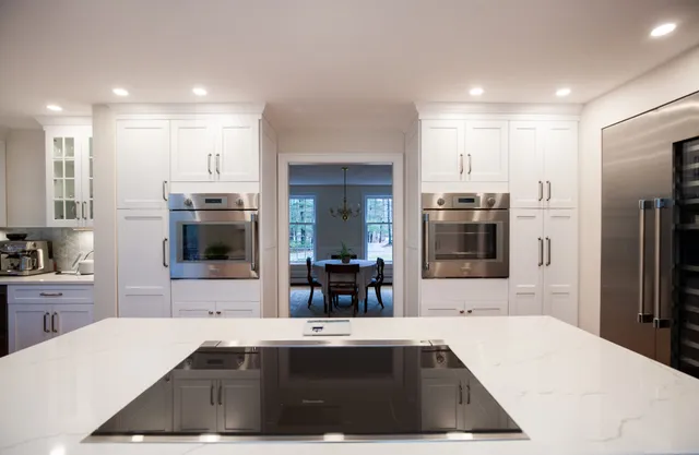 White kitchen with waterfall island and wall ovens