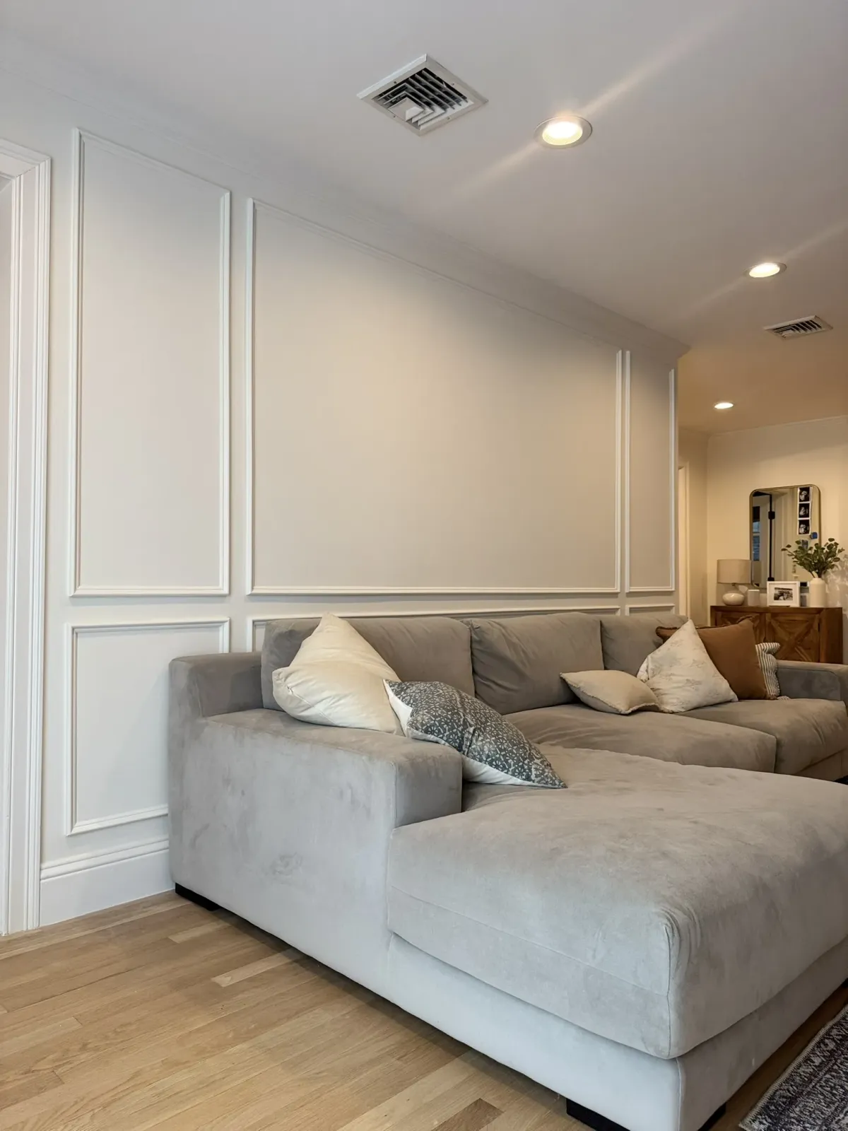 Wall panel millwork meeting the ceiling line and the door casing in a living room