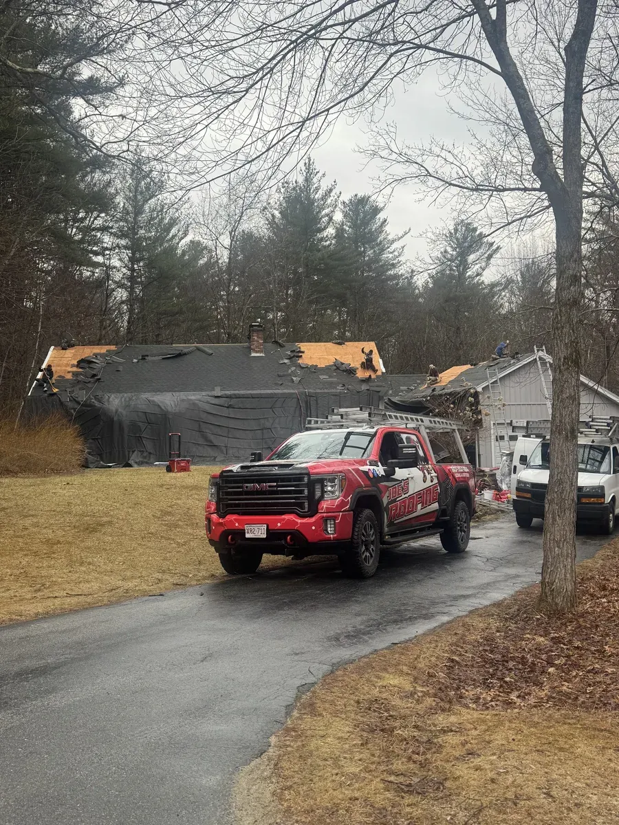 Roofers repairing storm damage on a residential roof