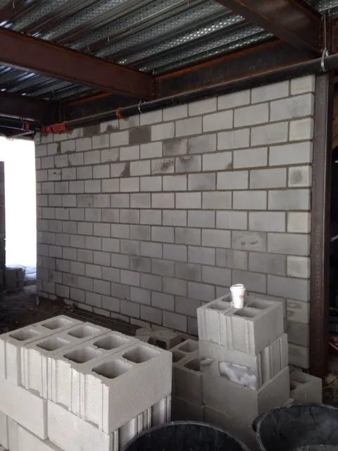 Concrete block wall laid up under structural steel framing