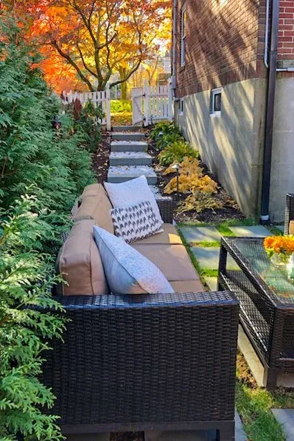 Outdoor seating area with evergreen hedge as backdrop and bluestone steps up slope