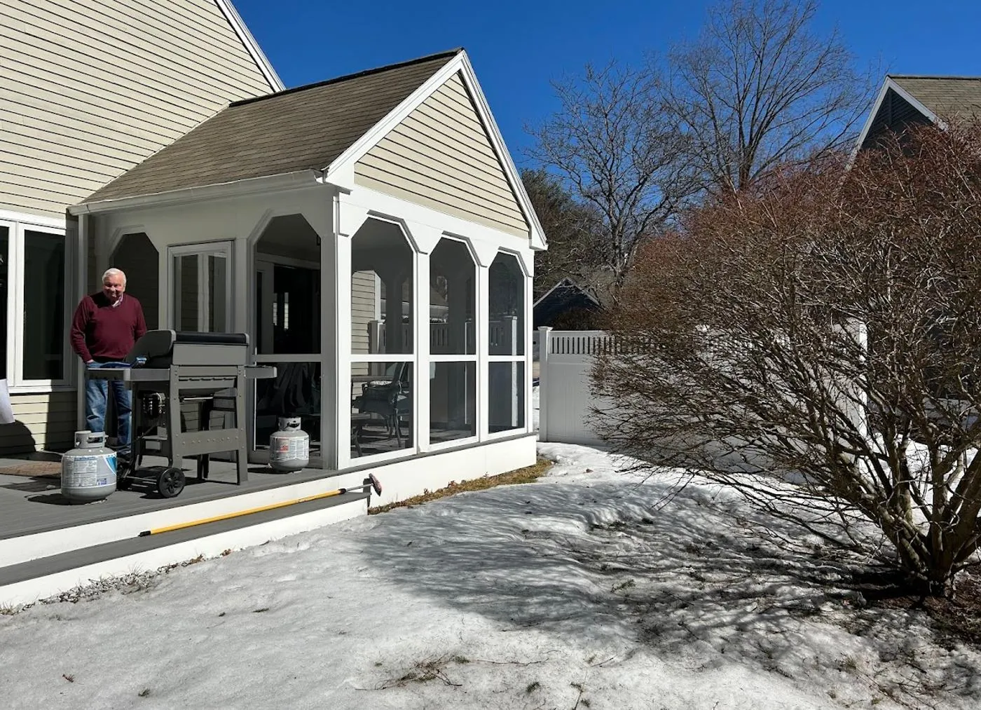 New screened-in porch addition with white trim and composite deck landing by NH Total Home Care