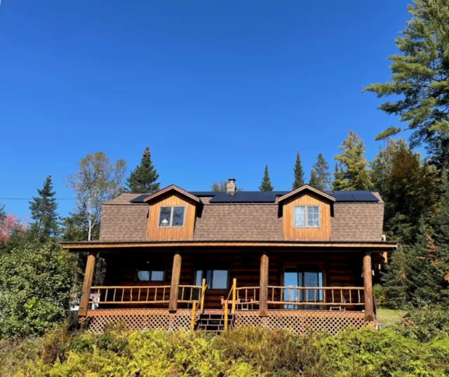 Granite State Solar solar panels on a log cabin in New Hampshire, showcasing rural residential solar energy installations