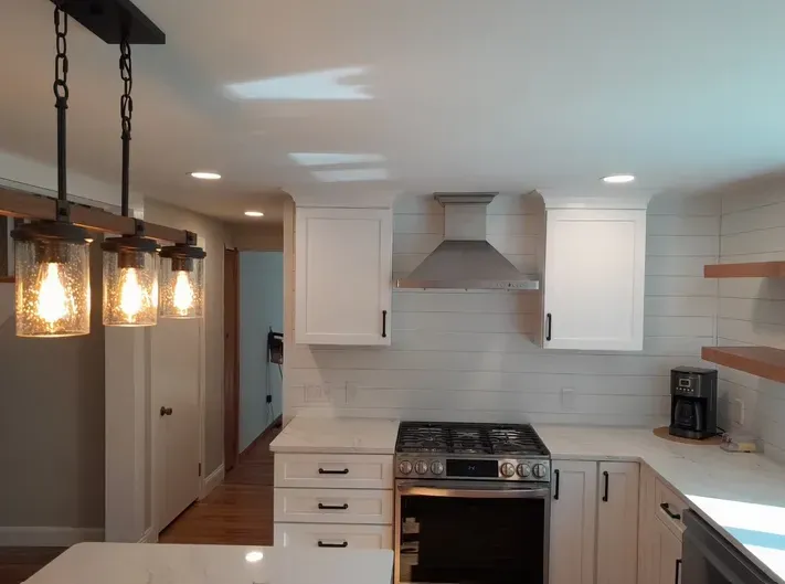 A kitchen with white cabinets and a stove top oven.