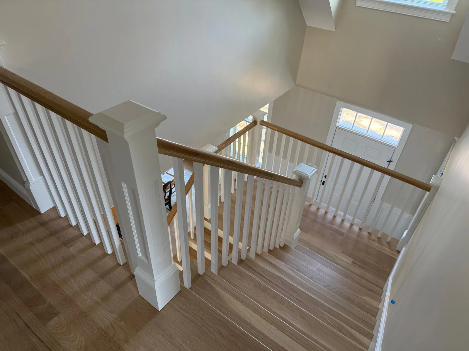 Custom staircase with white balusters and wood railings built by Miranda Finish Carpentry in New England