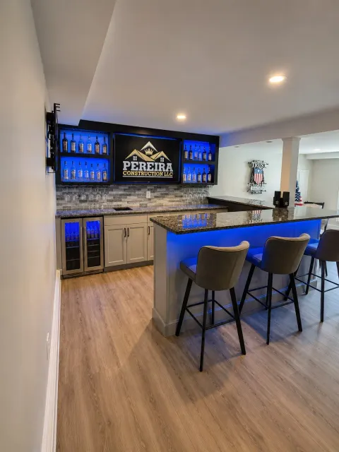 Completed custom basement bar with blue accent lighting