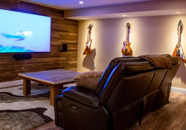 Custom basement home theater room in Hanover MA featuring embedded speaker wiring and luxury vinyl plank flooring by Almar Building Remodeling