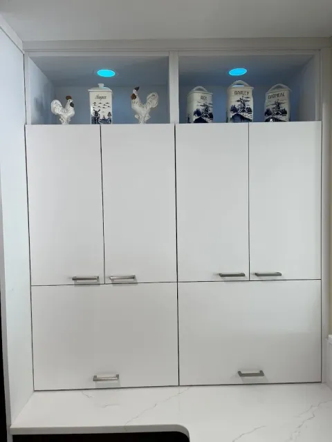 light blue colored recessed lighting installed in open upper cabinets to illuminate the decor in the cabinets