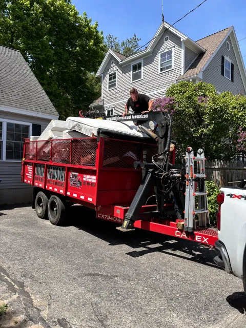 Finally Freedom Junk Removal loading junk mattresses into their trailer
