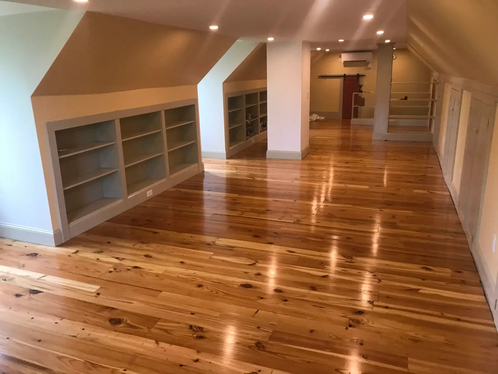 Renovated attic with reclaimed loblolly pine flooring. Builtins