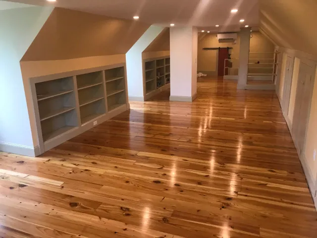 Renovated attic with reclaimed loblolly pine flooring. Builtins
