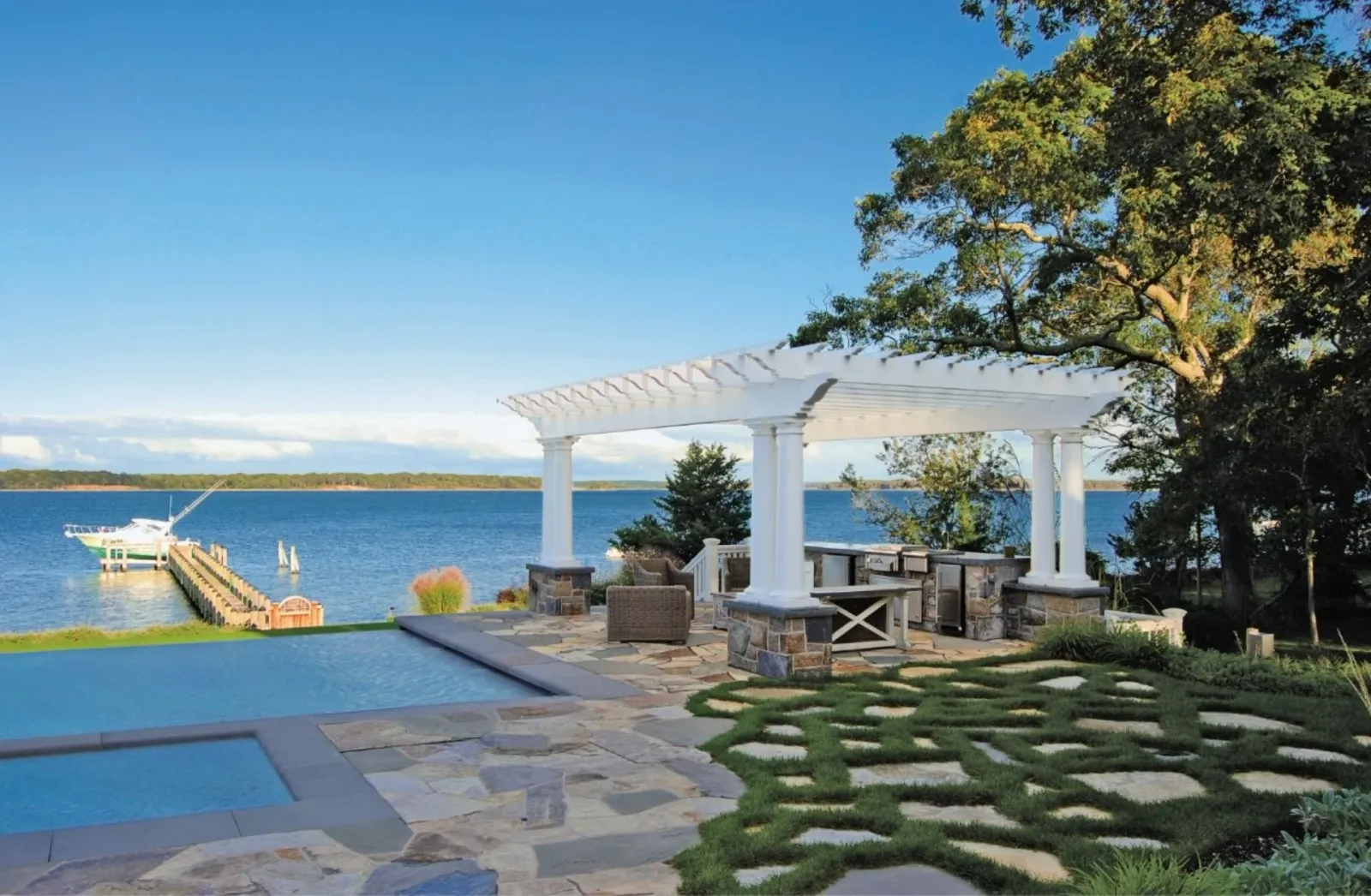 Pergola overlooking ocean with a dock and boat