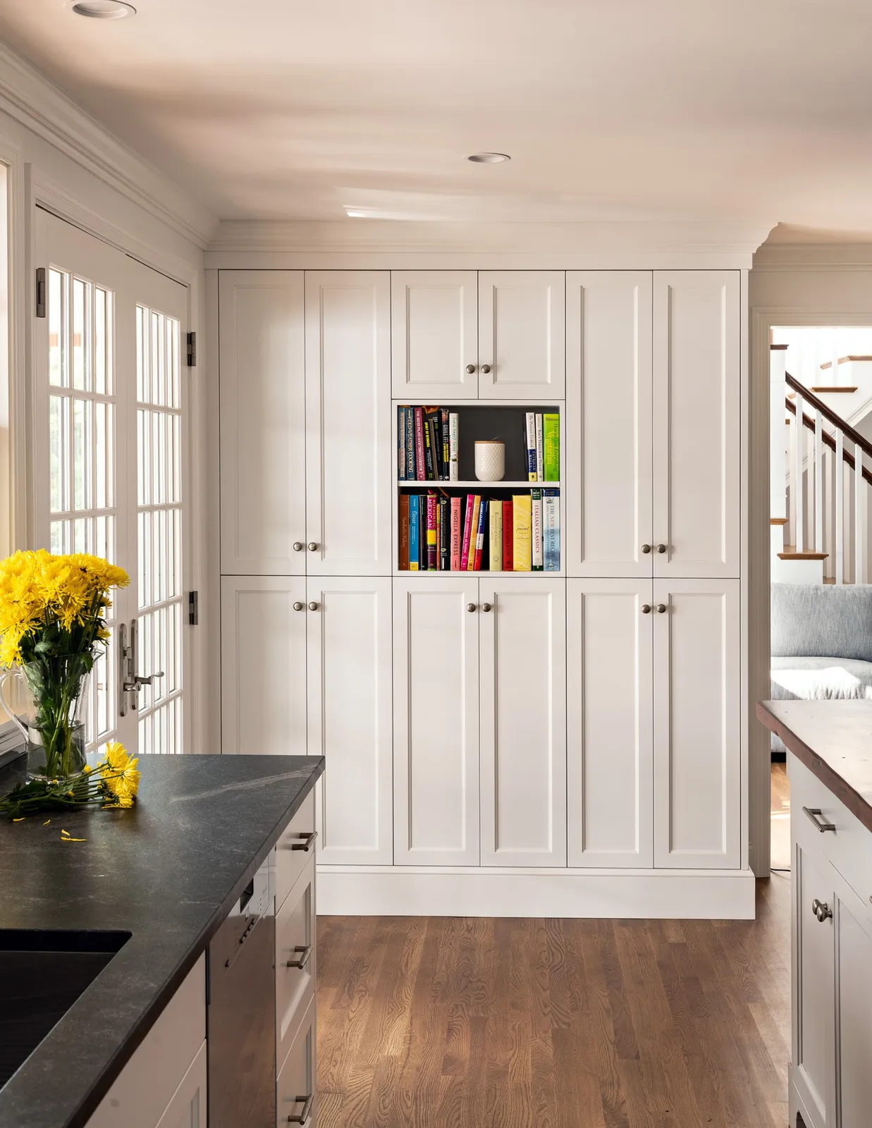In a thoughtfully designed renovation, custom millwork does more than add storage—it brings character, continuity, and purpose to the entire home.

In this Orleans residence, full-height kitchen cabinetry maximizes storage while maintaining clean, balanced proportions. The custom island adds warmth and craftsmanship with its wood countertop, paneled base, and finely detailed columns.

Beyond the kitchen, built-in cabinetry and open shelving turn otherwise unused wall space into functional architectural features. Surrounding the fireplace, the millwork was carefully integrated with the mantel and existing trim to create a seamless backdrop for books, artwork, and personal collections.

From consistent door reveals and thoughtfully scaled moldings to the balance of concealed storage and open display, every detail contributes to a home that feels refined, functional, and distinctly its own.

Architect: @frankshirleyarchitects
Photography: @dancutronaphoto

#CapeAssociates #CustomMillwork #CustomCabinetry #ArchitecturalMillwork #KitchenDesign #BuiltInCabinetry #CapeCodHomes #HomeRenovation #Craftsmanship