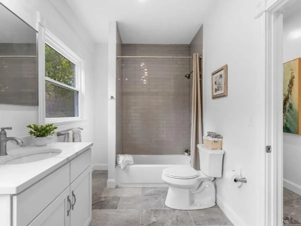 A bathroom with a toilet , sink , tub and shower.
