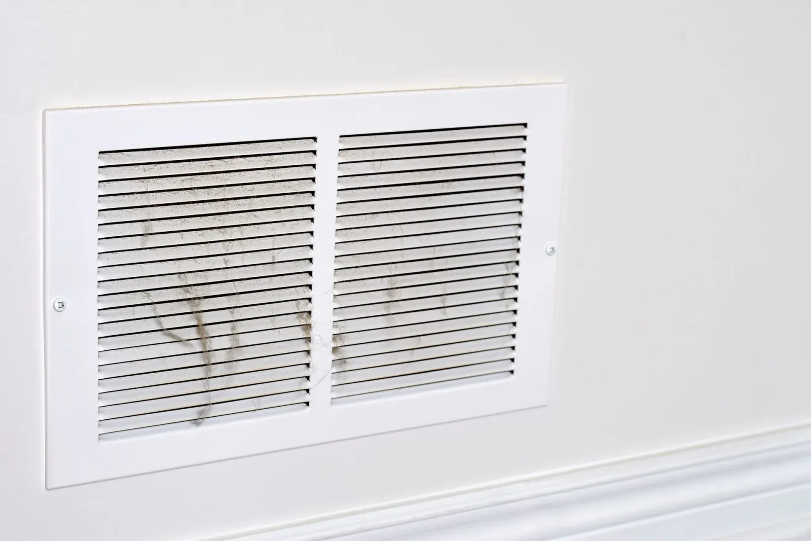 White wall vent cover with two louvered grilles and a small mark on the left panel.