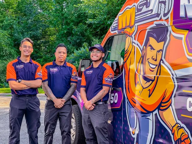 Three New Era team members pose in front of a service vehicle