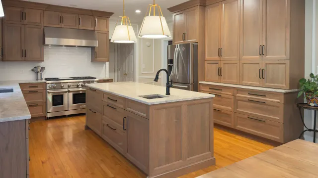 Modern Woodbridge kitchen featuring custom Wellsford cherry cabinetry with a warm grey stain and Perla Venata Quartzite countertops.