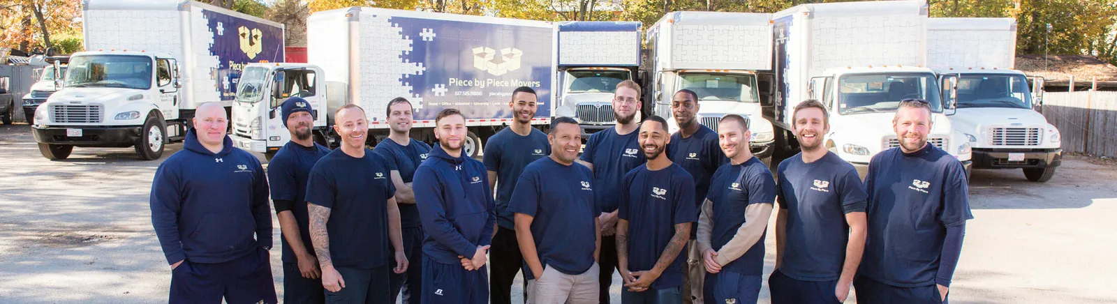 Crew in front of the branded Piece by Piece Movers fleet