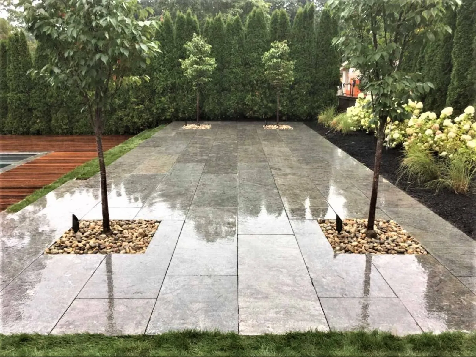 Large-format stone patio with tree plantings