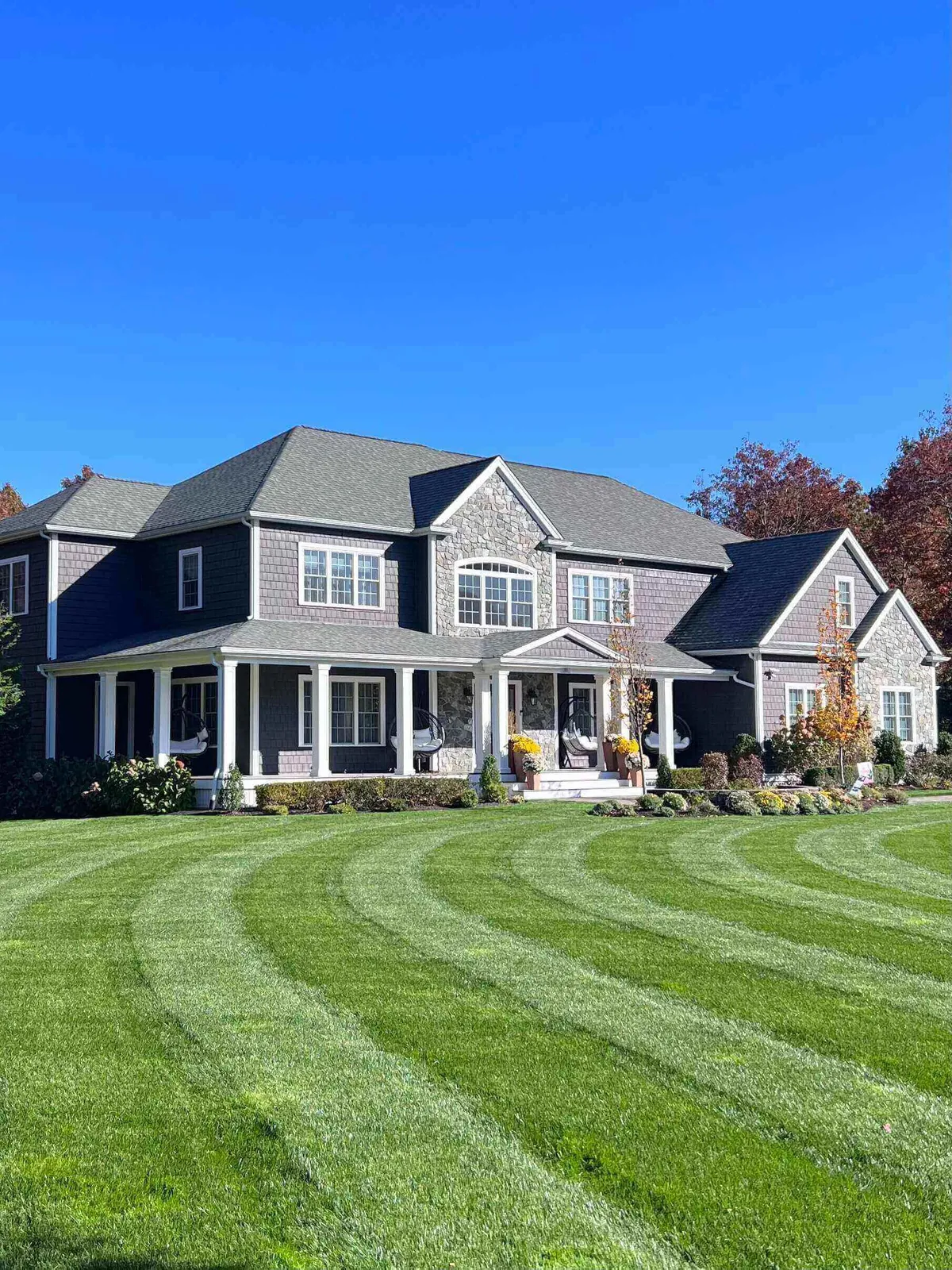 Large house with manicured lawn, clear sky.