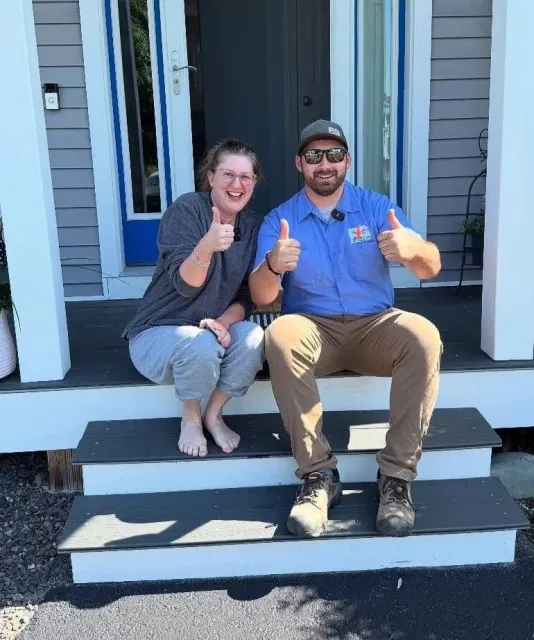 Parker Gammon and happy customer sitting on customer's front steps. Both doing thumbs up sign.