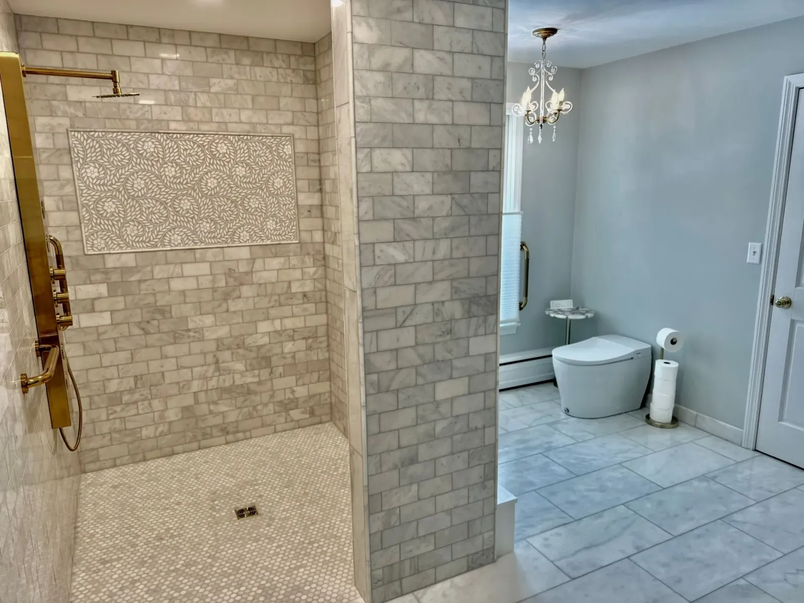 Bathroom with tiled shower on left and separate toilet area on right, in light neutral colors