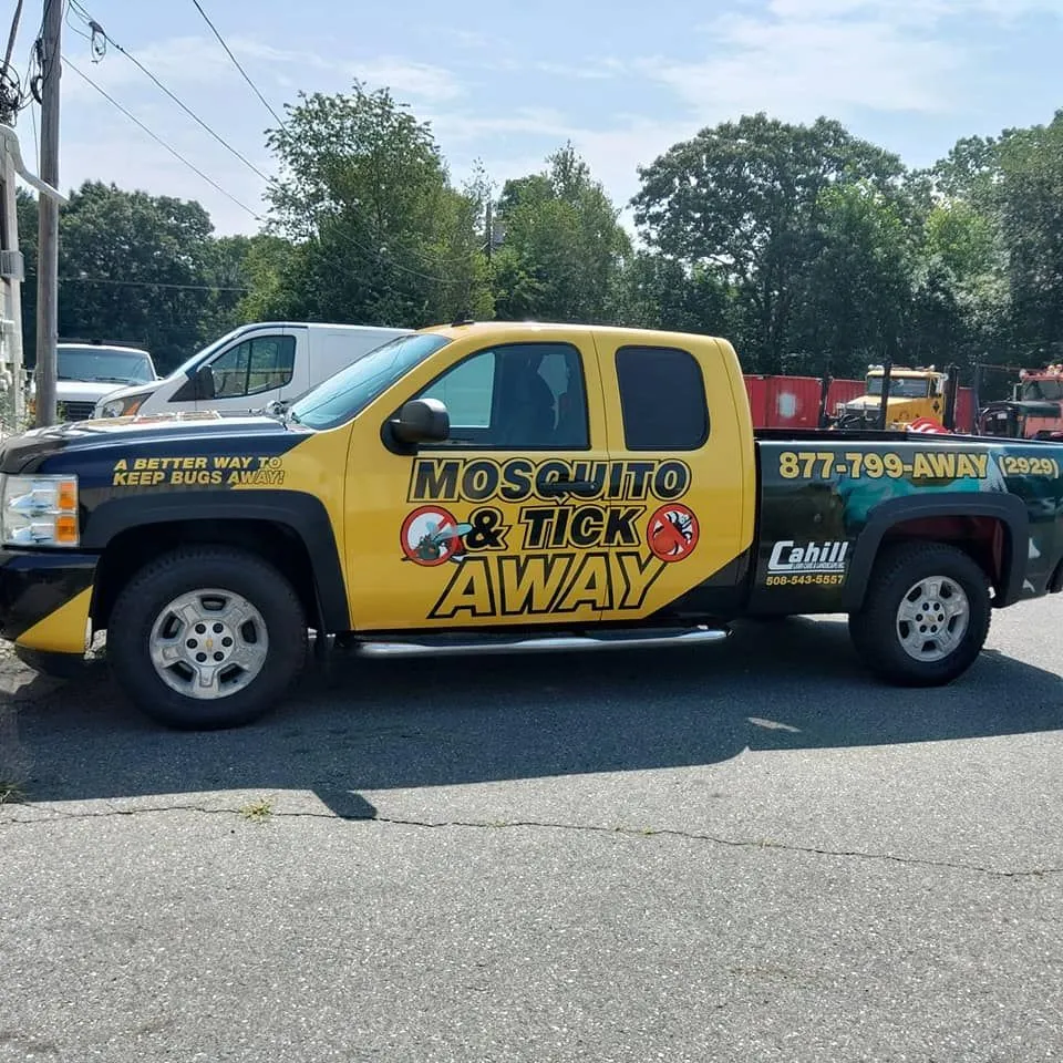 Yellow mosquito control truck with “Mosquito Stik Away” branding parked outdoors.