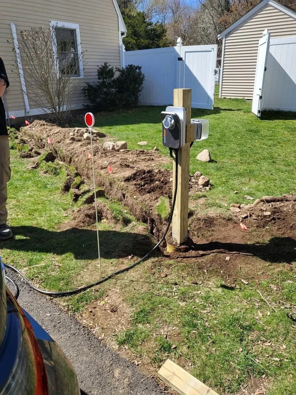 Installation of an electric vehicle charging station in a residential yard.