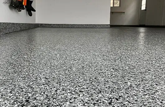 Close-up of a durable multi-layered grey flake epoxy garage floor system installed by RL Epoxy Flooring in Manchester, NH.