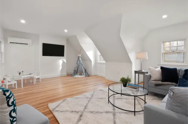 Bright Boston living room with a small kids’ play area, teepee tent, gray sofa, and round coffee table