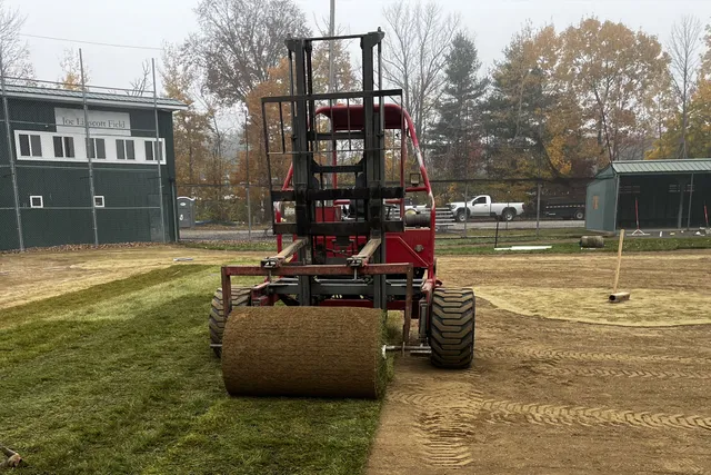 Machine rolling out turf on a baseball field