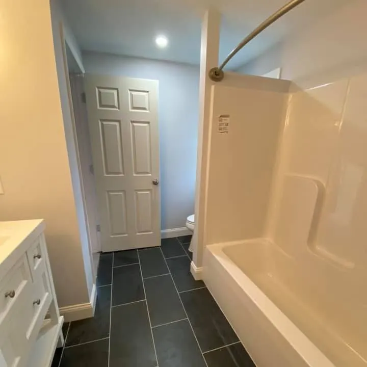 Completed bathroom remodel with tub, vanity and tile floor