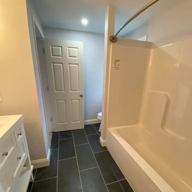 Completed bathroom remodel with tub, vanity and tile floor