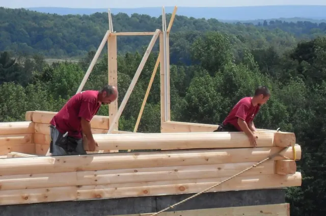 Two men are working on a wooden structure.