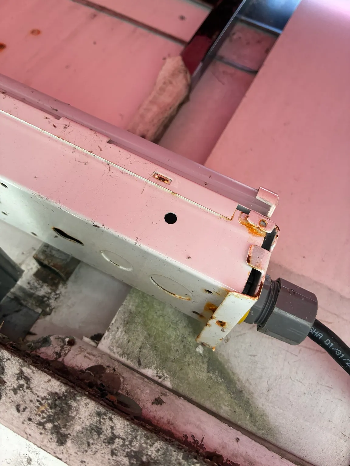 Corrosion on old commercial exterior light fixture before replacement
