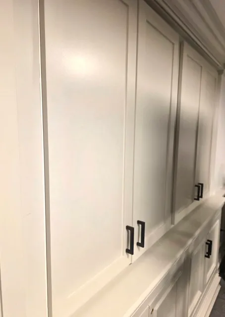White kitchen cabinets with black handles.