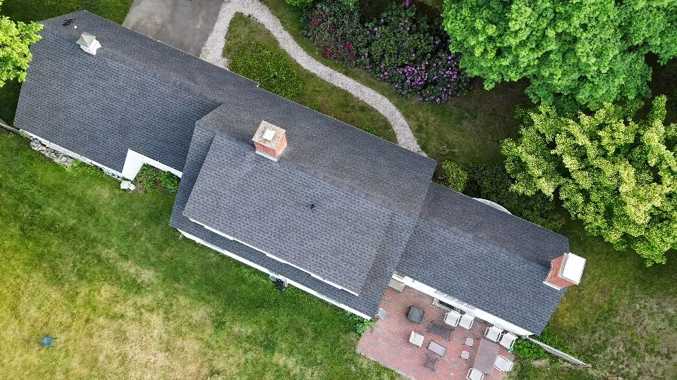 An aerial view of a house with a lot of trees in the background.