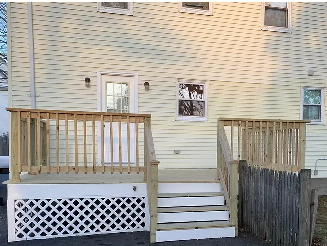 The back of a house with a wooden deck and stairs