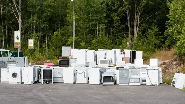 EZ-Haulin' team removing old appliances, including refrigerators and washers, for eco-friendly disposal and recycling.