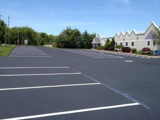 An empty parking lot with a building in the background