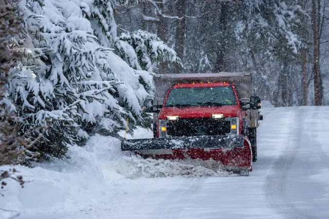 Truck plowing a snowy road in winter