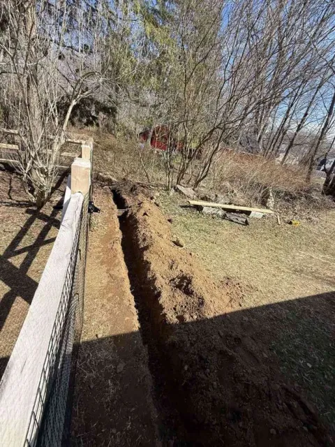 French drain trench excavation along fence line on CT shoreline property