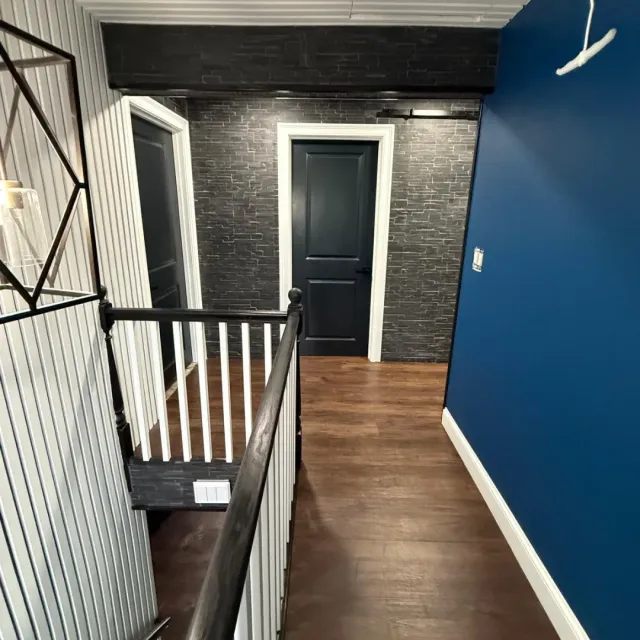 Interior hallway renovation with stone accent wall and navy paint in Cambridge, MA — Tinbercraft Construction
