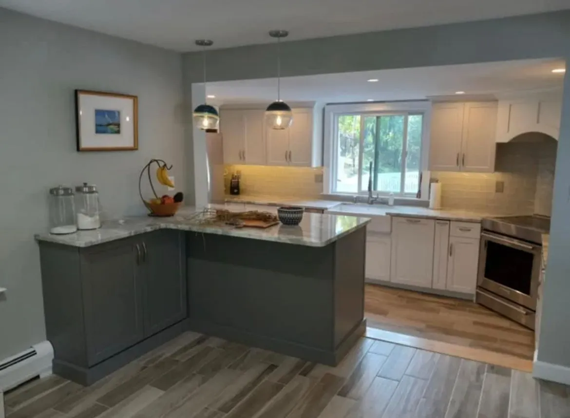 A kitchen with a large island and white cabinets